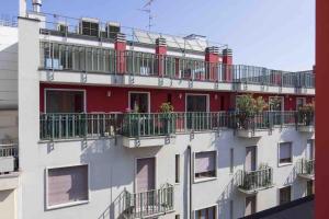 een rood-wit gebouw met balkons erop bij Contempora Apartments - Cavallotti 13 - B14 in Milaan