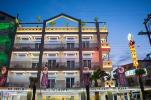 a tall white building with a sign in front of it at Hotel Europe in Paralia Katerinis