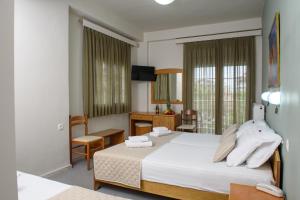 a hotel room with two beds and a television at Hotel Europe in Paralia Katerinis