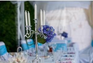 ソポトにあるHotel Shterev Anevoの蝋燭花瓶の青い花のテーブル