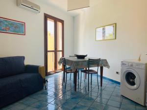 a living room with a table and a washing machine at Vivaldi Appartamenti in Marinella di Selinunte