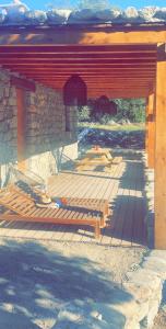 a wooden deck with a building with a red roof at La bergerie du Chêne in Omessa