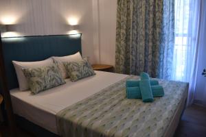 a bedroom with a bed with a blue pillow on it at Athena's Apartments & Studios in Sykia Chalkidikis