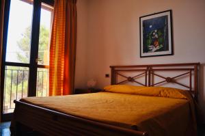 ein Schlafzimmer mit einem Bett und einem großen Fenster in der Unterkunft Case Vacanza Vivaldi in Marinella di Selinunte