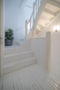 un pasillo blanco con escaleras y una maceta en Apollonas Luxurious Apartments en Atenas