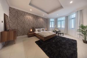 a bedroom with a large bed and a black rug at Stella Stays Magnificent 4 BDR Palm Villa Beach Private Pool in Dubai