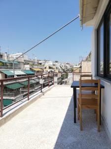a wooden bench sitting on top of a balcony at 5th floor apartment with city view in Athens