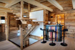 a wooden cabin with a spiral staircase in a room at Chalet Sabaroc - OVO Network in La Giettaz