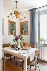 アレッツォにあるScacciapensieri Guest Houseのダイニングルーム(白いテーブル、椅子付)