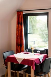 a dining room table with a red and white table cloth at B&B Hier en Nu in Heusden