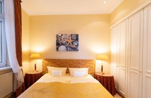 a bedroom with a large bed with two lamps at Strandhotel Sylt Westerland in Westerland