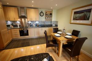 a kitchen with a wooden table and chairs and a dining room at City Centre Skeldergate 2 Bed Apartment with Parking in York