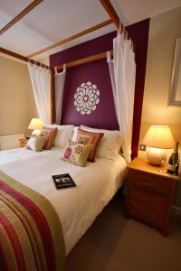 ein Schlafzimmer mit einem großen Bett mit einem lila Kopfteil in der Unterkunft City Centre Skeldergate 2 Bed Apartment with Parking in York