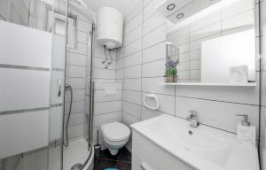 a white bathroom with a toilet and a sink at Apartments Korina 2866 in Kampor