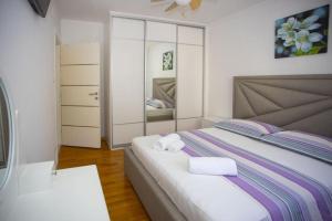 een slaapkamer met een bed met twee handdoeken erop bij Apartment San Marino in Makarska
