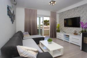 een woonkamer met een bank en een tv bij Apartment San Marino in Makarska