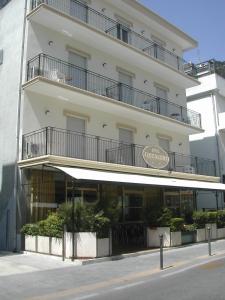 um grande edifício branco com varandas em cima em Hotel Graziella Mare em Rimini