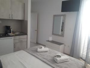 a white kitchen with two towels on a bed at Villa Rosso in Baška Voda
