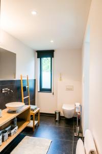 a bathroom with a toilet and a sink at B&B Hier en Nu in Heusden