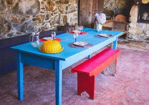 a blue table with plates and wine glasses and a bench at Casa da Quinta do Outeiro in Viana do Castelo