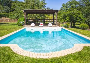 a pool with two lawn chairs and a gazebo at Casa da Quinta do Outeiro in Viana do Castelo