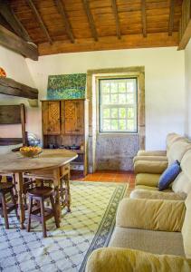 a living room with a table and a couch at Casa da Quinta do Outeiro in Viana do Castelo