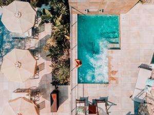 una vista sul soffitto di una piscina con sedie e ombrelloni di Can Cota Boutique - Turismo de interior a Selva