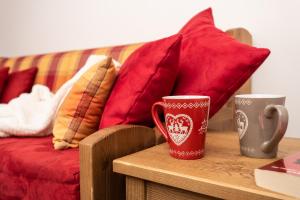 two coffee cups on a table next to a couch at Résidence Le Chamois d'Or in Val Thorens +53 photos