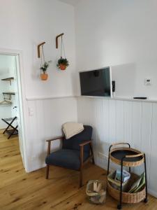 a room with a chair and a tv on a wall at Ferienwohnung Kleiner Onkel in Uhldingen-Mühlhofen