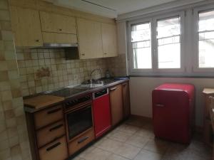 a kitchen with a red stove and a red refrigerator at Billenberghof in St. Gallen