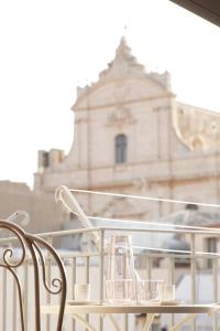 a group of glasses sitting on a table in front of a building at Appartamento Sweet Rose in Ispica