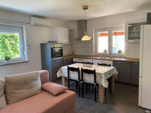 cocina con mesa con sillas y sofá en Apartma Lavanda, en Koper