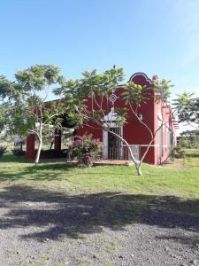 um edifício vermelho com uma árvore em frente em Hacienda Santa Clara, Morelos, Tenango, Jantetelco em Jantetelco