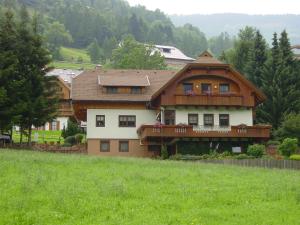 ein großes Haus auf einem Hügel auf einem Feld in der Unterkunft Haralds Ferienwohnungen in Bad Kleinkirchheim