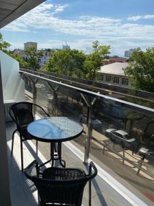 a table and chairs on a balcony with a view of a city at Hotel Vogue in Anapa