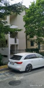 un coche blanco estacionado frente a un edificio en Apartments Radovic, en Petrovac na Moru