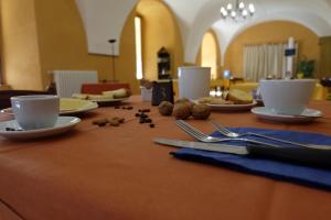 una mesa con platos, tazas y utensilios. en Hostel il Tetto, en Melfi
