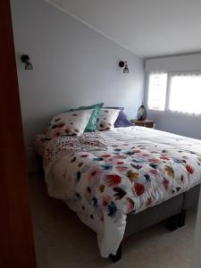 um quarto com uma cama com um edredão floral em L école buissonnière em Le Nouvion-en-Thiérache