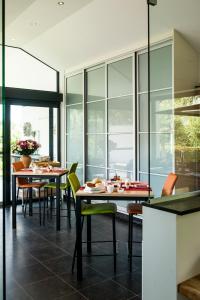 - une salle à manger avec des tables, des chaises et des fenêtres dans l'établissement B&B Hier en Nu, à Heusden