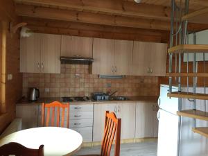 a kitchen with wooden cabinets and a table and chairs at Filkówka- Słoneczne Wzgórze in Wadowice +11 photos