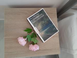 czasopismo siedzące na stole z różowymi kwiatami w obiekcie Freesia Grand Sea View Residence w mieście Sarláta