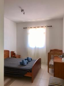 um quarto com uma cama com almofadas azuis em Cantinho Solpraia em Porto Santo