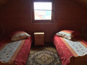 two beds in a small room with a window at Filkówka- Słoneczne Wzgórze in Wadowice