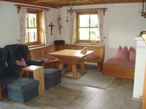 a dining room with a table and chairs and windows at Ferienwohnung Peschl Langdorf Bayerischer Wald in Langdorf
