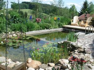 un jardín con un estanque con aitatingificialificialificialificialificialificialificial en Ferienwohnung Peschl Langdorf Bayerischer Wald, en Langdorf