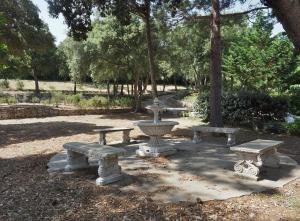 a park filled with lots of benches and trees at Domaine De Foresta in Bonifacio
