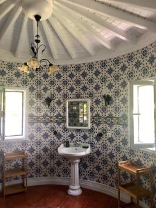 a bathroom with a sink and floral wallpaper at La VIGIE de CASTELROCK ( Casa Petunia ) in Mosteiros