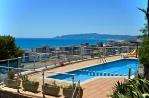 a swimming pool on top of a building with the ocean at Trill Las Brisas 2-4 pers in L'Estartit