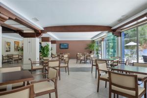 Un restaurante con mesas, sillas y ventanas. en Hotel Torre Azul & Spa - Adults Only, en El Arenal