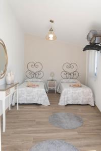 a room with two beds and a table and a mirror at Pensión Casa do Gallo Sarria in Sarria
